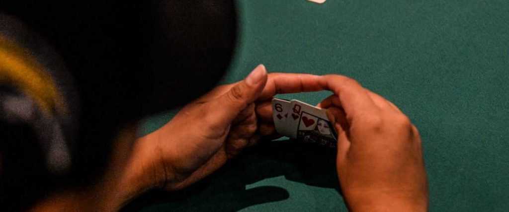 A poker player holding his cards.