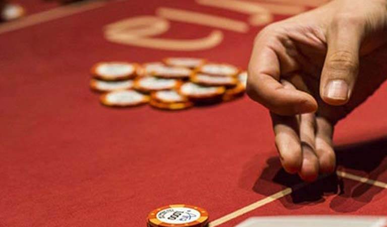 A hand dealing cards during a game of poker.