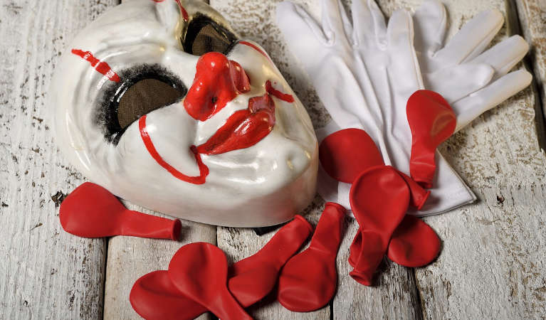 A mask and gloves worn by a clown.