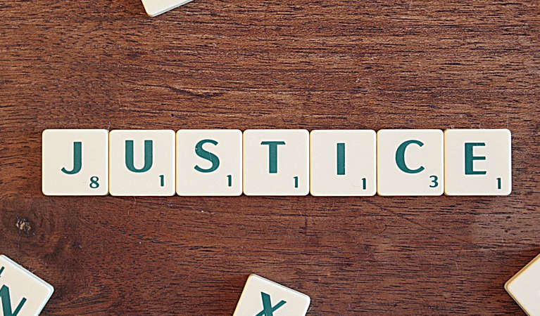 justice spelt with scrabble letters