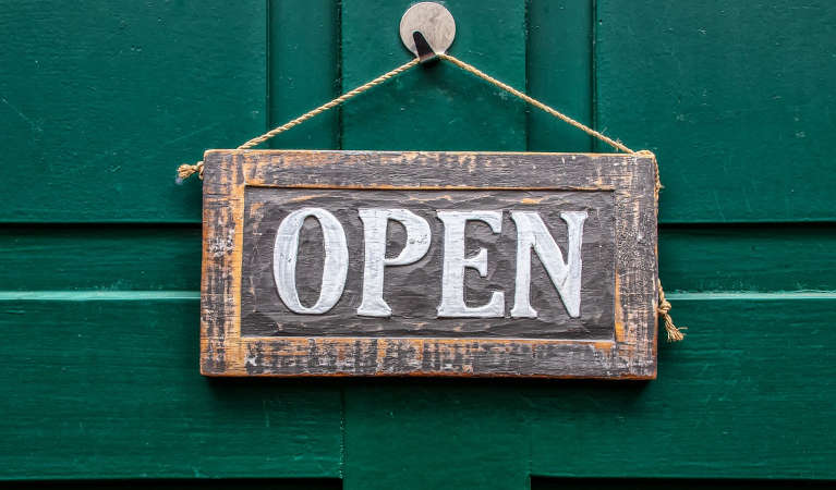 an-open-sign-against-a-green-door-background