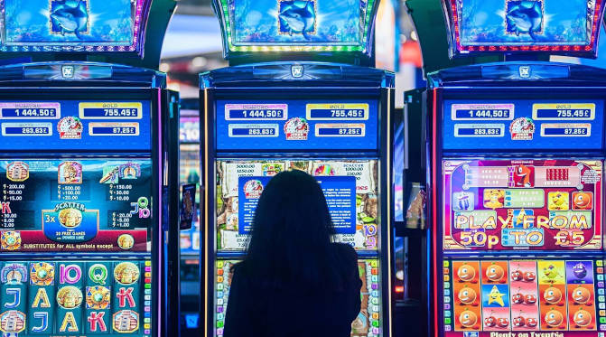 A lone female casino patron playing at a slot machine in a a casino in Las Vegas.